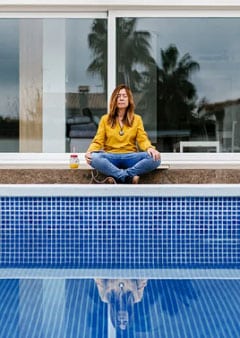 Woman sitting by a pool
