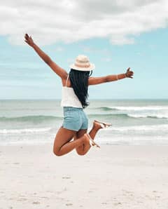 Woman jumping for joy on the beach